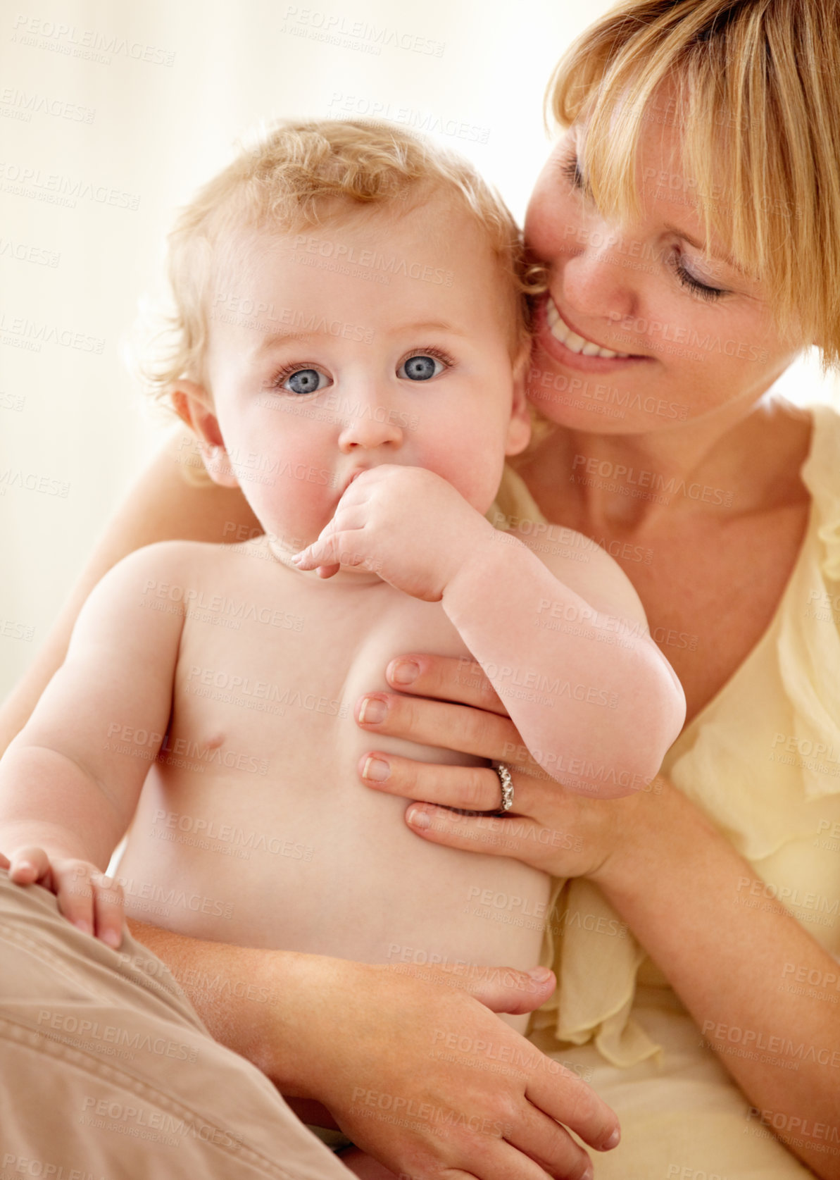 Buy stock photo Cute baby boy looking at you while being held by his smiling mother