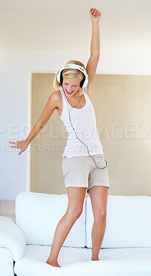 Buy stock photo A young woman dancing around while listening to songs on her headphones