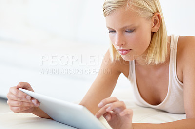Buy stock photo A young woman working on her digital tablet