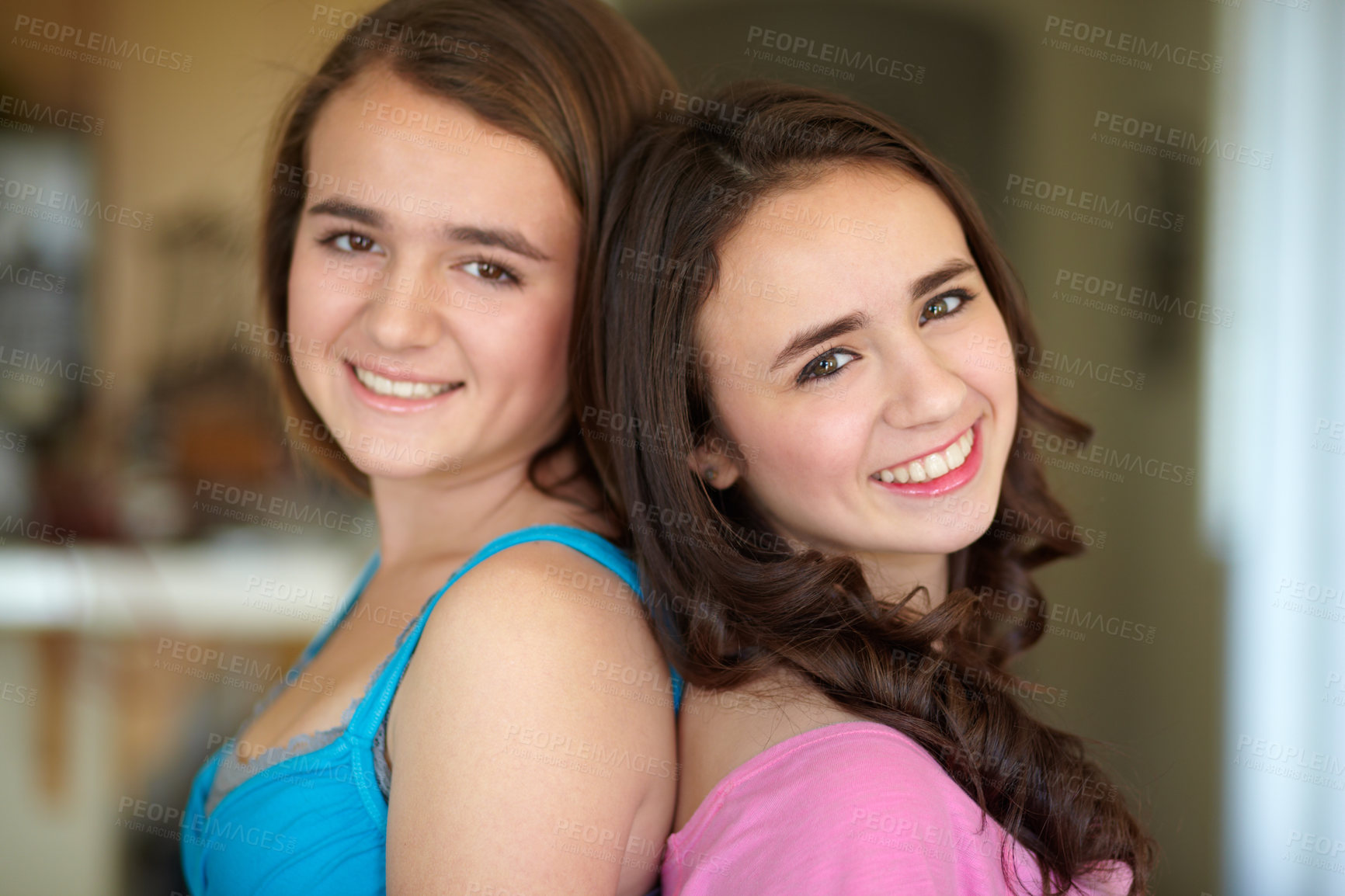 Buy stock photo Happy sisters, portrait and standing back to back for family, friends or teens together at home. Face of female people, siblings and smile for friendship, relationship or young women in the house