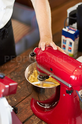 Buy stock photo A Baker mixing the cupcake mix with his mixer