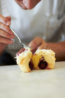 Buy stock photo Close up of a baker putting frosting on a cupcake that is cut in half to show the chocolatey centre