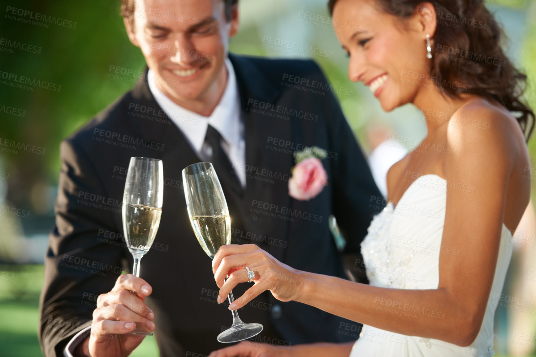 Buy stock photo Cropped view of a young bride and groom standing together and toasting their marriage