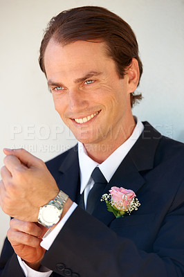 Buy stock photo A happy groom adjusting his wristwatch before the wedding ceremony