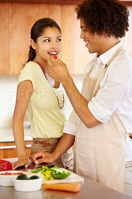 Buy stock photo A young man feeding his girlfriend a bite of pepper