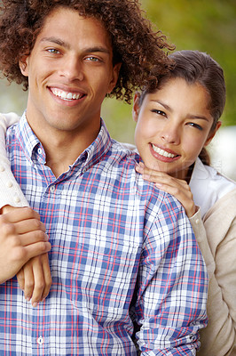 Buy stock photo Portrait of a beautiful mixed race couple smiling together outdoors