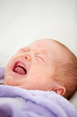 Buy stock photo Sad, crying or tantrum with a baby on a bed closeup in a home for emotion, expression or child development. Face, tired or hungry with a newborn infant in the bedroom of an apartment for growth