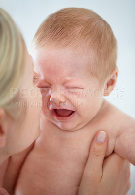 Buy stock photo Closeup cropped shot of a mother cradling her crying infant