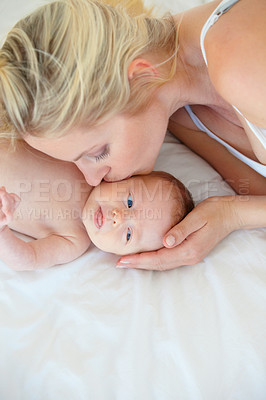 Buy stock photo Mother, parent and baby with kiss, love and playing with care, bonding together in a bed and relax. Mom, kid and single mum in a home, happiness or nursery with child, infant and playing with family