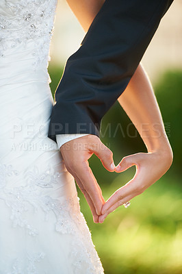 Buy stock photo Cropped image of a newlywed couple making a heart with their hands