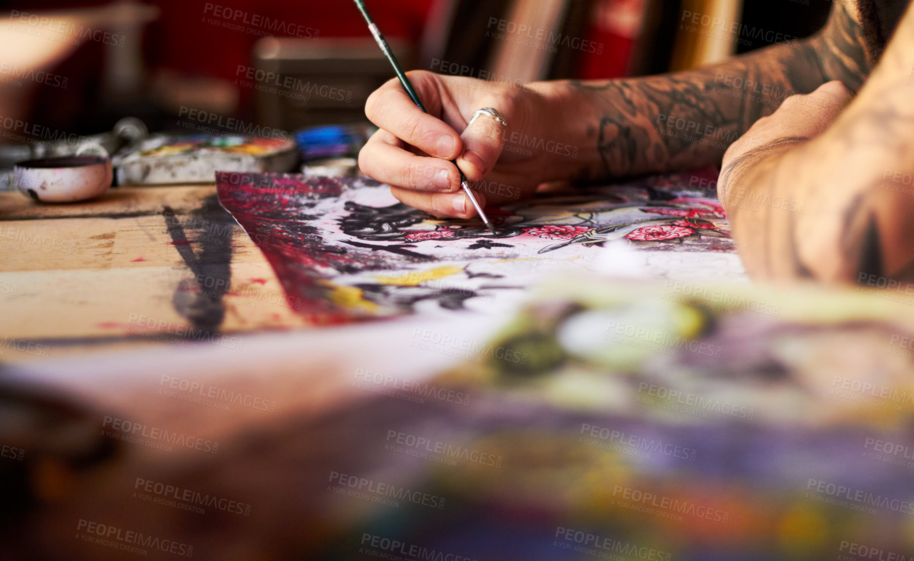 Buy stock photo A closeup of a tattoo artist using colour and a paintbrush working on his latest piece of art work