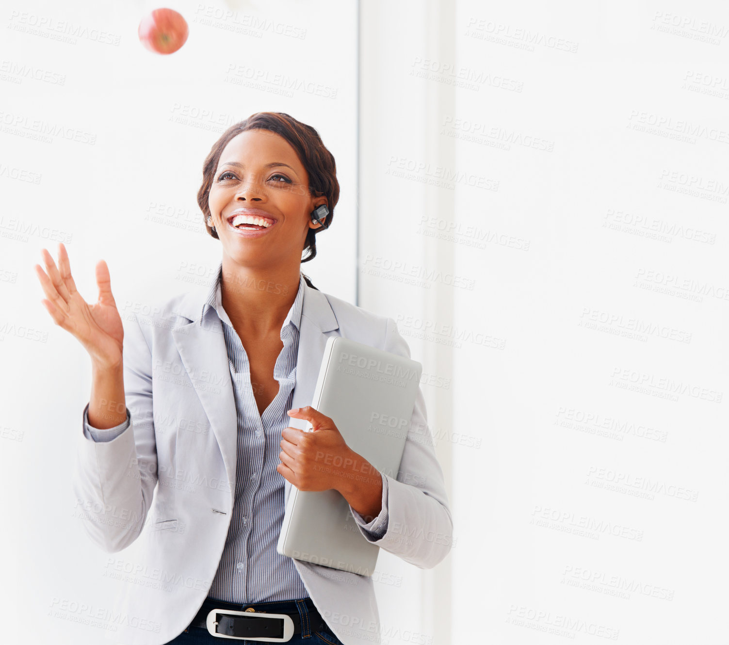 Buy stock photo A young african american businesswoman tossing an apple into the air
