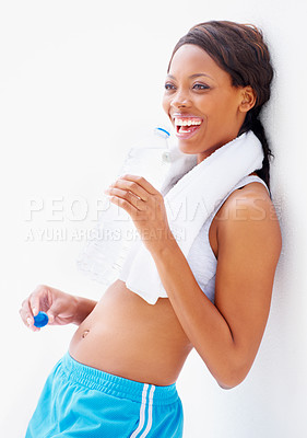 Buy stock photo Smiling young african in gymwear with a towel around her neck while drinking some water