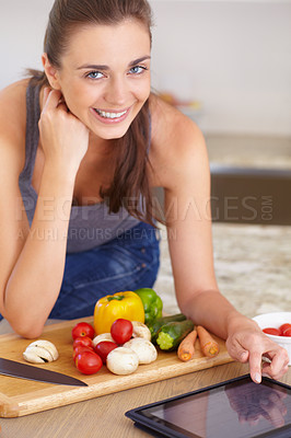 Buy stock photo Portrait of a beautiful young woman looking for recipes online while cooking