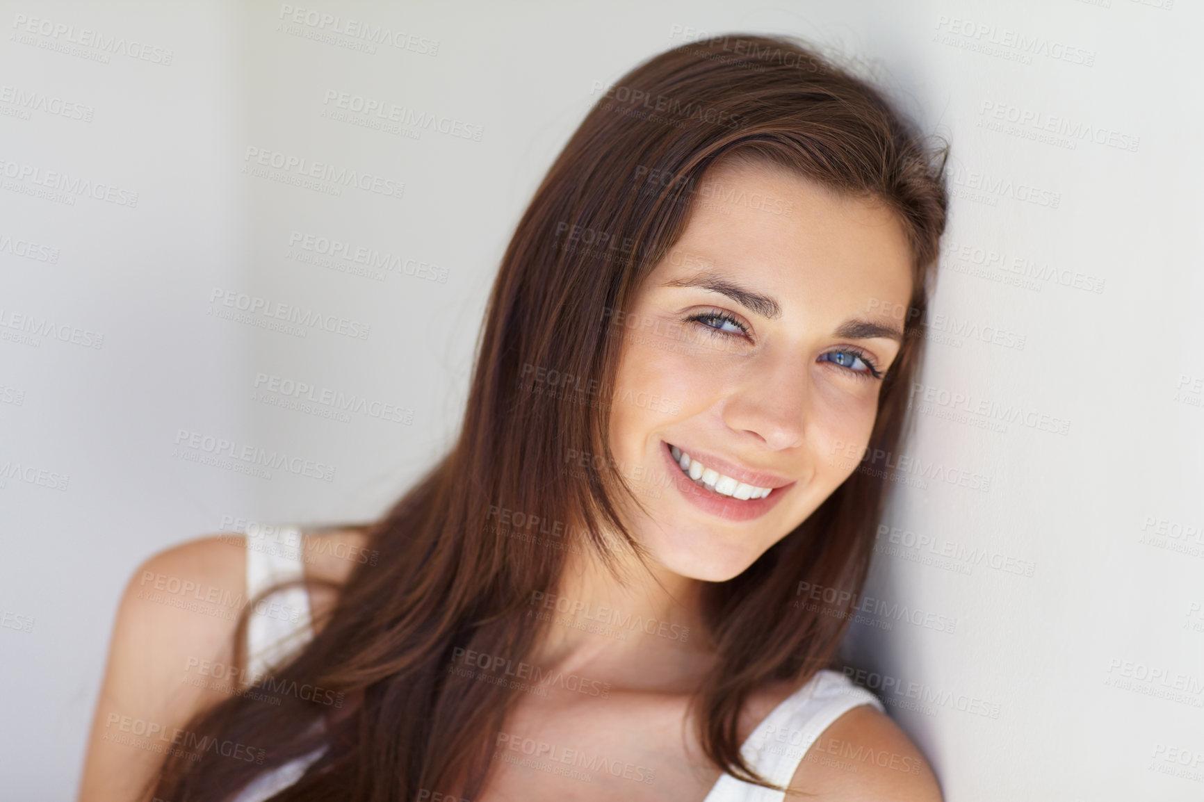 Buy stock photo Portrait of a casually dressed young woman leaning against a wall