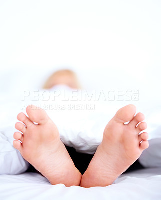 Buy stock photo Home, closeup and person with feet, bed and relax in the morning, sleeping and weekend break with linen. Human, apartment and foot with bedroom, comfort or dreaming with blanket, resting or mattress