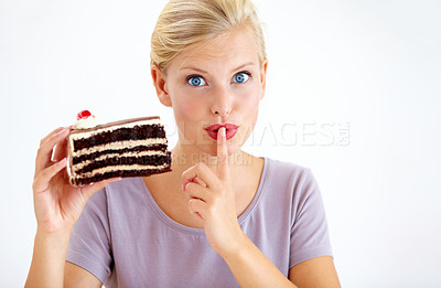 Buy stock photo Secret, cake and young woman in a studio cheating on healthy, wellness or weight loss diet. Yummy, sweet and female person from Australia eating a chocolate dessert isolated by white background.