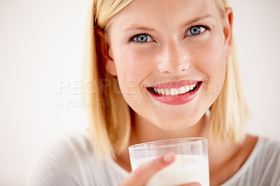 Buy stock photo Dairy, woman drinking a glass of milk and in a white background with a smile. Health wellness or natural nutrition, healthy and female person drink with happy face in a studio background smiling