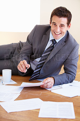 Buy stock photo Portrait of a handsome young businessman working on the floor of his office