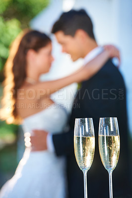 Buy stock photo Champagne, happy couple and blurred embrace at wedding with love, smile and commitment at reception. Wine glasses, woman and man hugging at marriage celebration event, partnership and future together