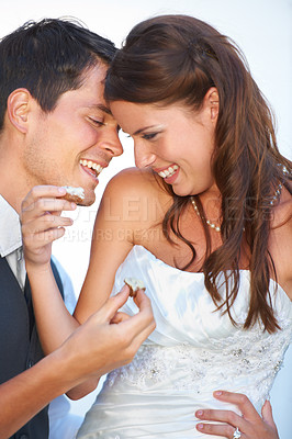 Buy stock photo Happy, wedding and couple eating cake together for celebration of love together at party. Smile, cute and young bride feed husband sweet dessert at romantic marriage ceremony or event with commitment