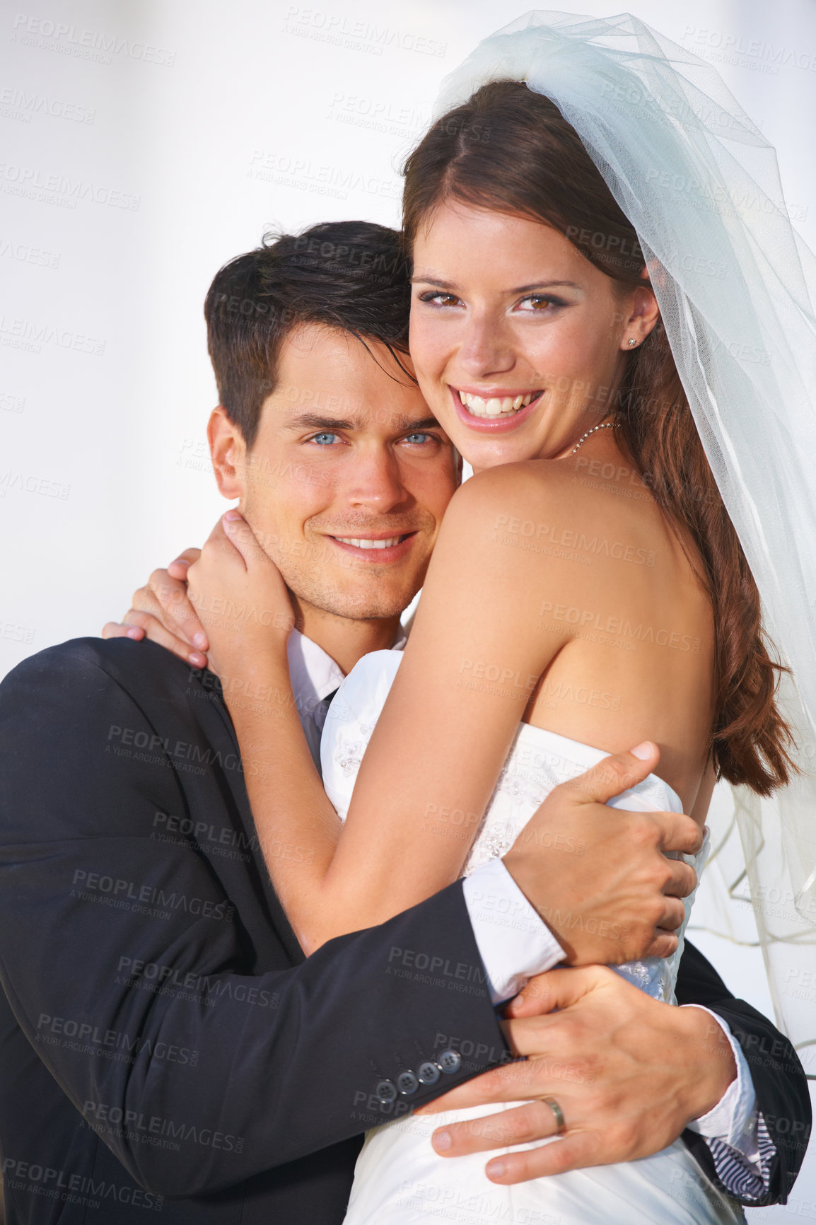 Buy stock photo Portrait of a couple of young newlyweds embracing warmly and smiling at the camera