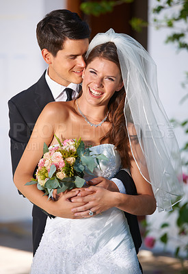 Buy stock photo Portrait of a newlywed couple embracing outside on their big day