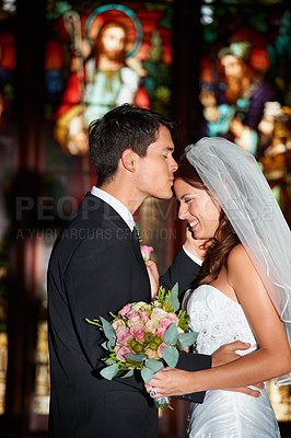 Buy stock photo Wedding, marriage or ceremony with a bride and groom in a church or chapel for the tradition of vows. Married couple, love or trust with a man kissing a woman on the forehead as newlywed people