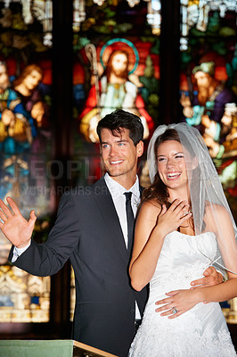 Buy stock photo Couple, face and happy in church for wedding, ceremony or event with commitment, wave and union. Marriage, man and woman with smile, joy and love for celebration, loyalty and trust with suit or dress