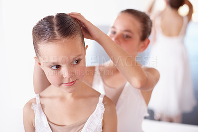 Buy stock photo Ballet, children and help with hair in studio, academy or gym, dancer friends training together. Young girl ballerina students in dance class with support, trust and learning practice for performance