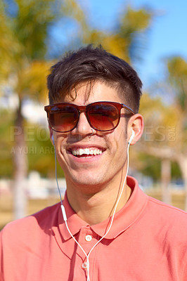 Buy stock photo A happy young man listening to music in the sun