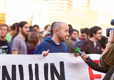 Buy stock photo Shot of a protestor being interviewed at a rally