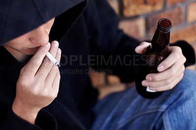 Buy stock photo Topview of a person wearing a hoody, smoking and holding a bottle of beer