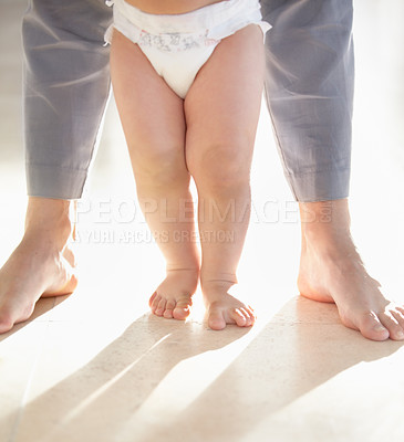 Buy stock photo Cropped image of the legs of a baby walking with a parent supporting from behind