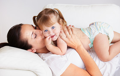 Buy stock photo A cute little girl being kissed by her mother