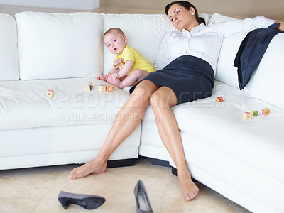 Buy stock photo Exhausted young working mother asleep on the couch next to her baby