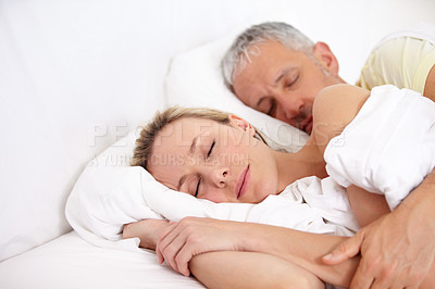 Buy stock photo Love, tired and mature couple sleeping in bed for cuddling together on weekend morning at home. Calm, peaceful and man and woman taking a nap and dreaming in bedroom for bonding at modern apartment.