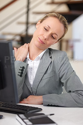 Buy stock photo A businesswoman sitting at her desk and stretching her neck