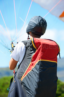 Buy stock photo Man, parachute or paragliding launch in nature, exercise or healthy adventure for extreme sport. Person, strings or training for outdoor fitness for wellness, helmet or safety gear by blue sky