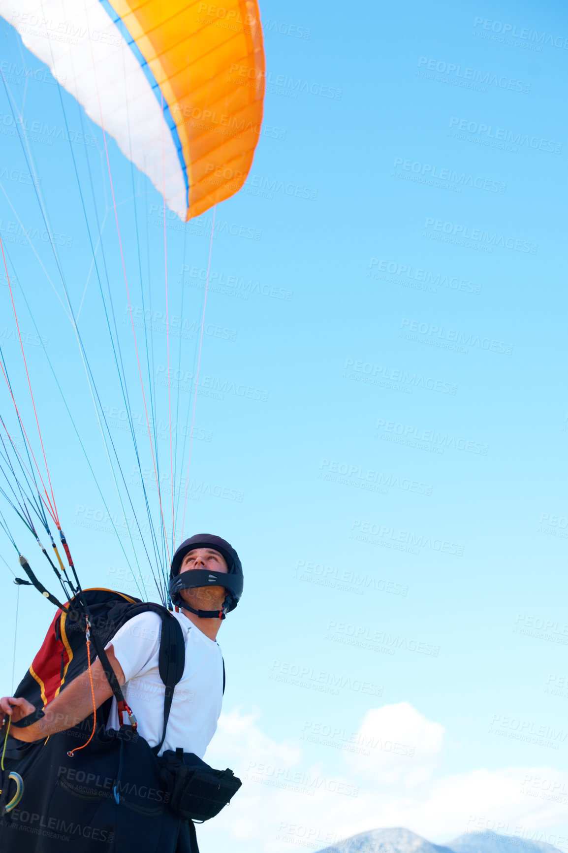 Buy stock photo Shot of a man paragliding on a sunny day