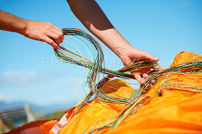 Buy stock photo Closeup shot of a man preparing his paragliding equipment