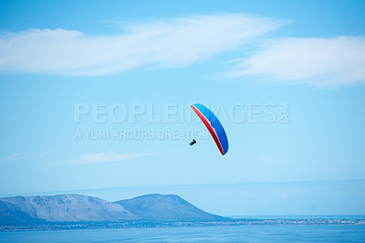 Buy stock photo Pilot, parachute and paragliding in blue sky for flight, freedom and courage with extreme sport. Athlete, glide and fearless in outdoor fitness for adventure, health and sports by ocean with mountain