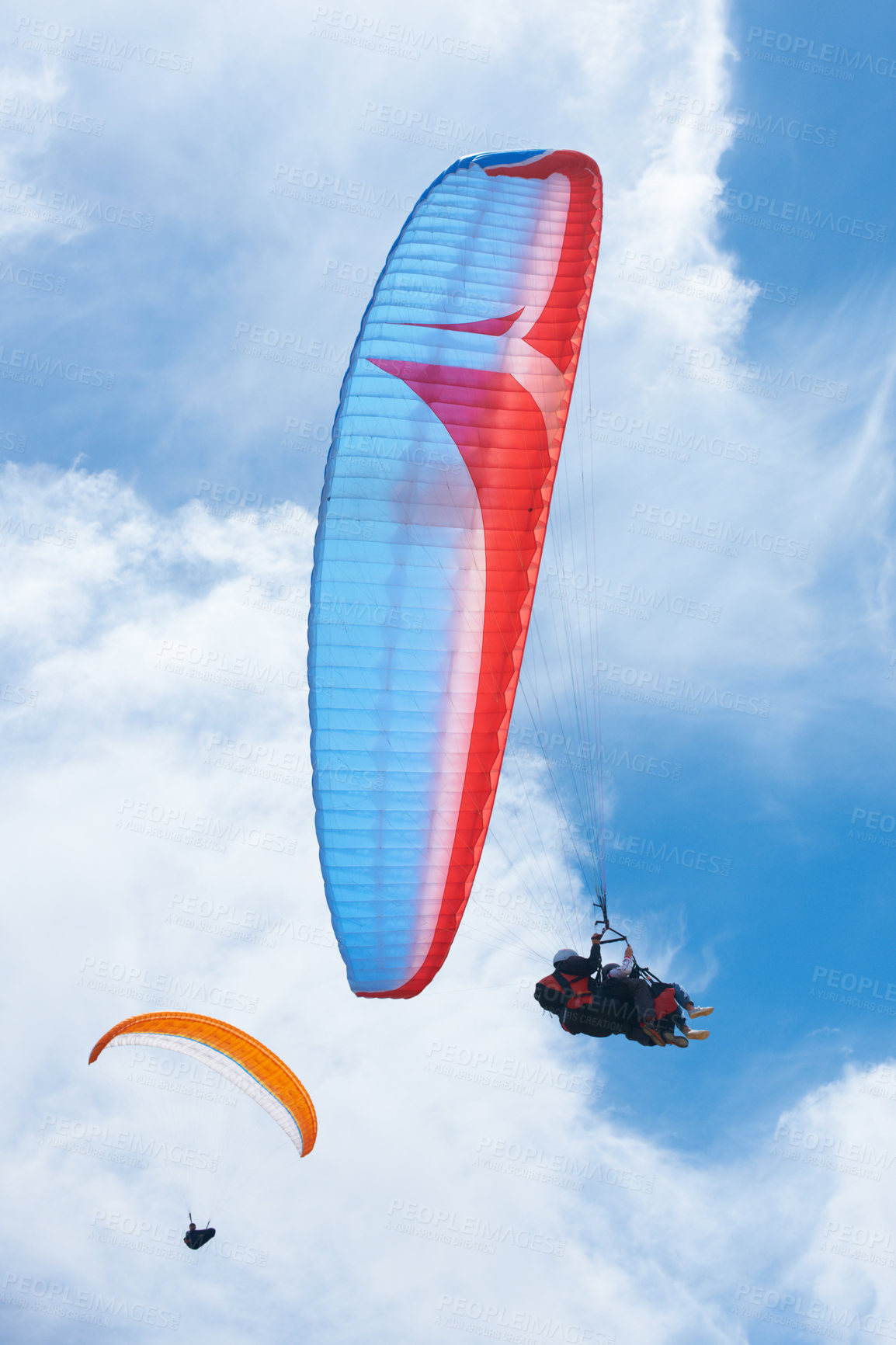 Buy stock photo Person, parachute and paragliding in blue sky for flight, stunt and courage with extreme sport. Athlete, glide and fearless in outdoor fitness for adventure, health and sports by ocean with mountain