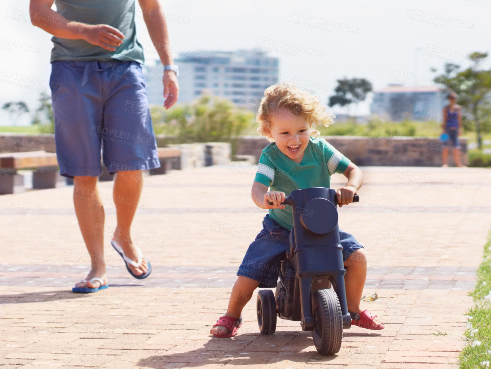 Buy stock photo Happy, toy and motorbike with child and father playing in park for bonding, laugh and fun. Smile, happiness and energy with man and young boy riding on scooter for playful, youth and summer