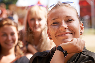 Buy stock photo portrait of happy young woman smiling with chin rested on her hand and friends sitting in the background