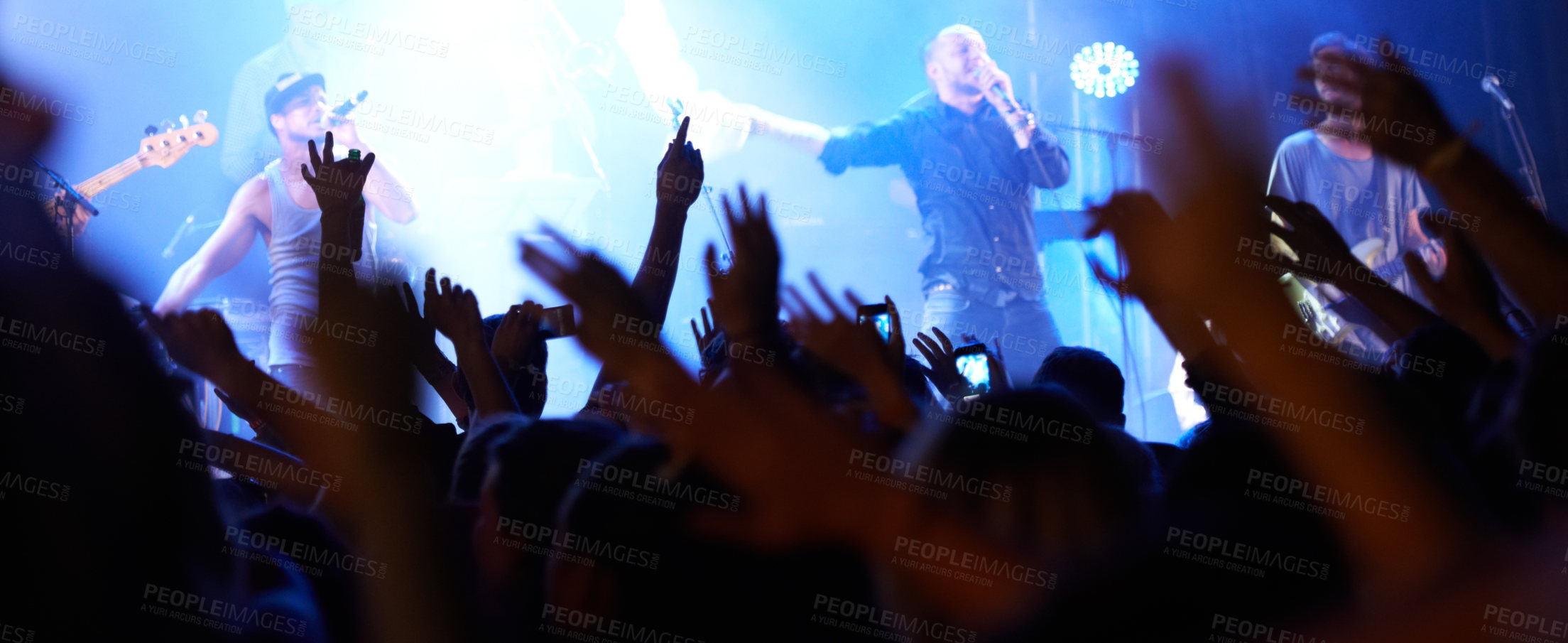 Buy stock photo Rearview of an audience with hands raised at a music festival