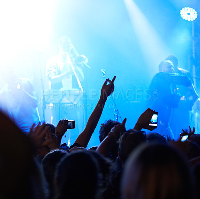 Buy stock photo Rearview of an audience with hands raised at a music festival