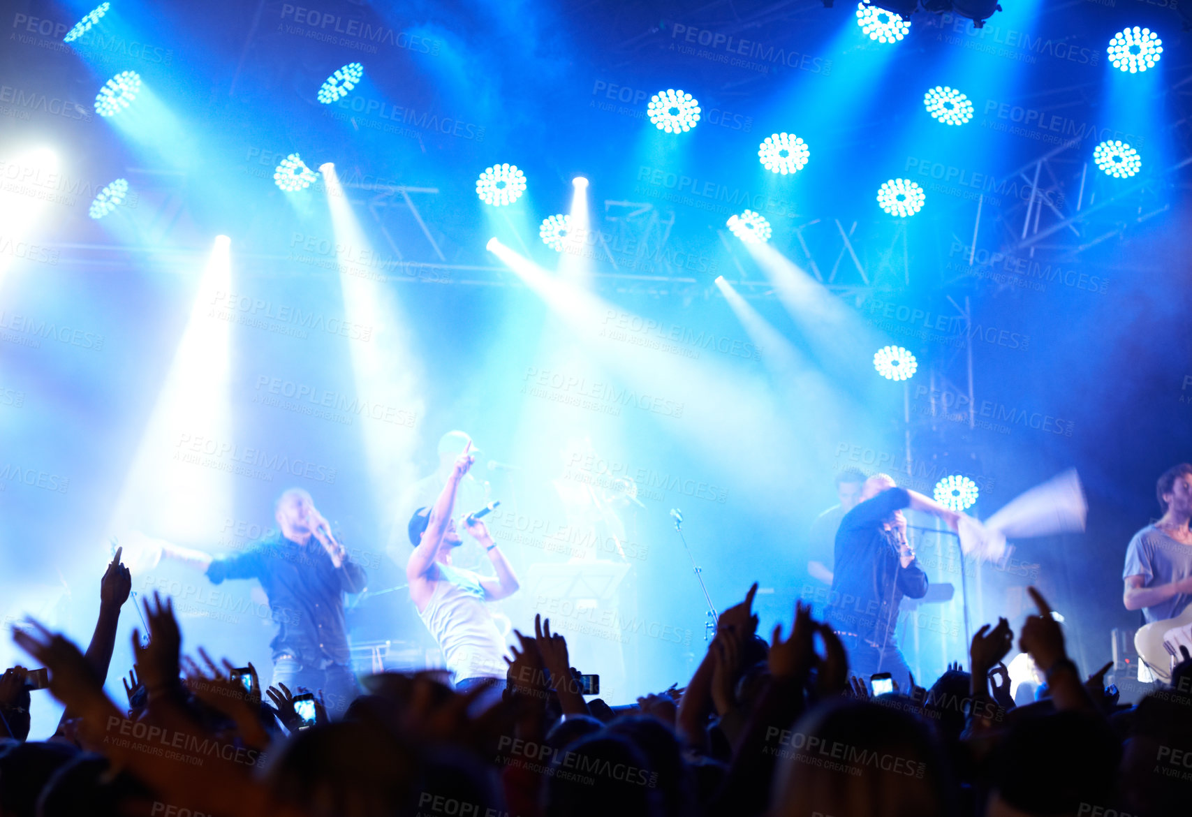 Buy stock photo Concert crowd, music festival lights or band audience listen rock, metal or celebrity star, artist or stage performance. Night show energy, excited group celebrate and fans cheers for musician singer