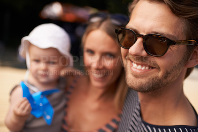 Buy stock photo A a smiling handsome man standing with wife and baby in the background