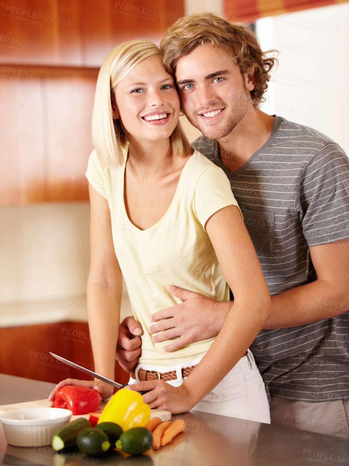 Buy stock photo Portrait of a happy young couple standing in the kitchen